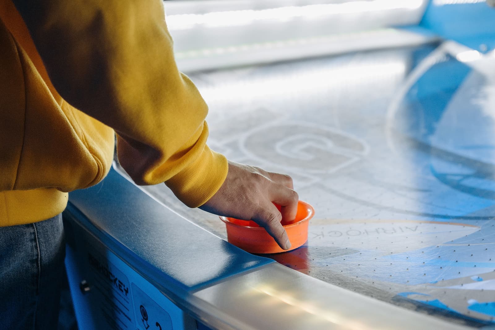 A puck and mallet on an air hockey surface