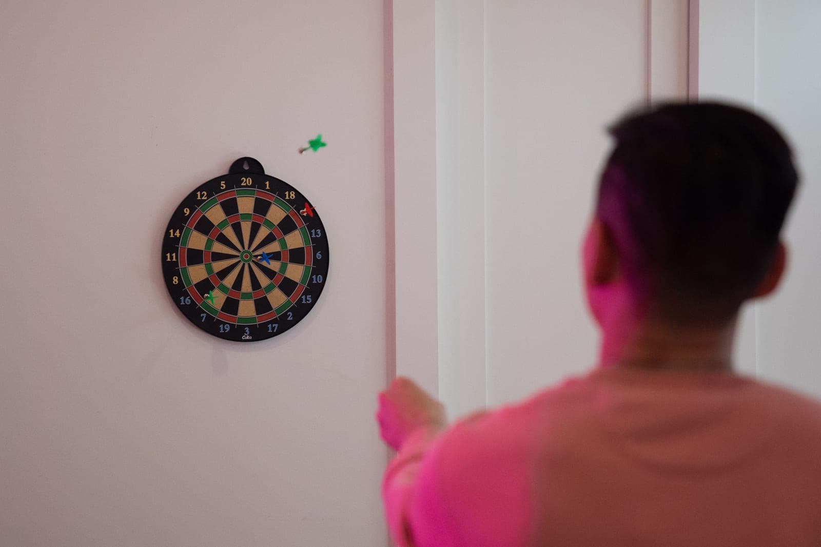 A backboard panel behind a wall-mounted dartboard