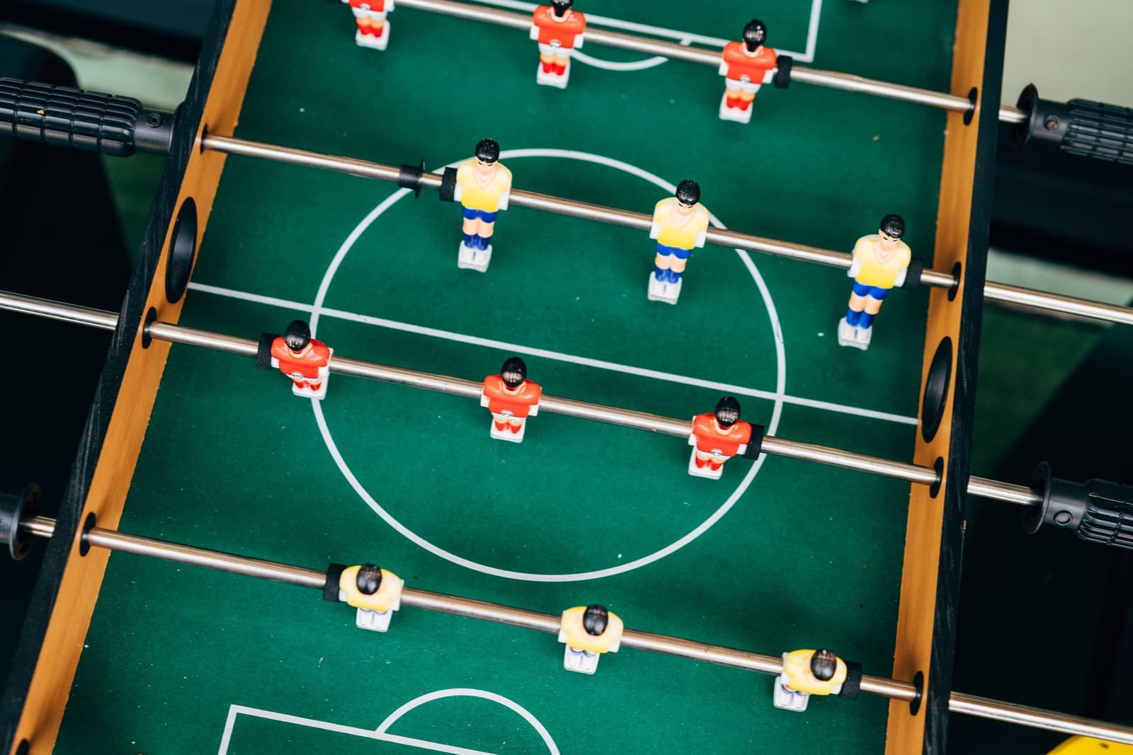 A family-room foosball table against a wall