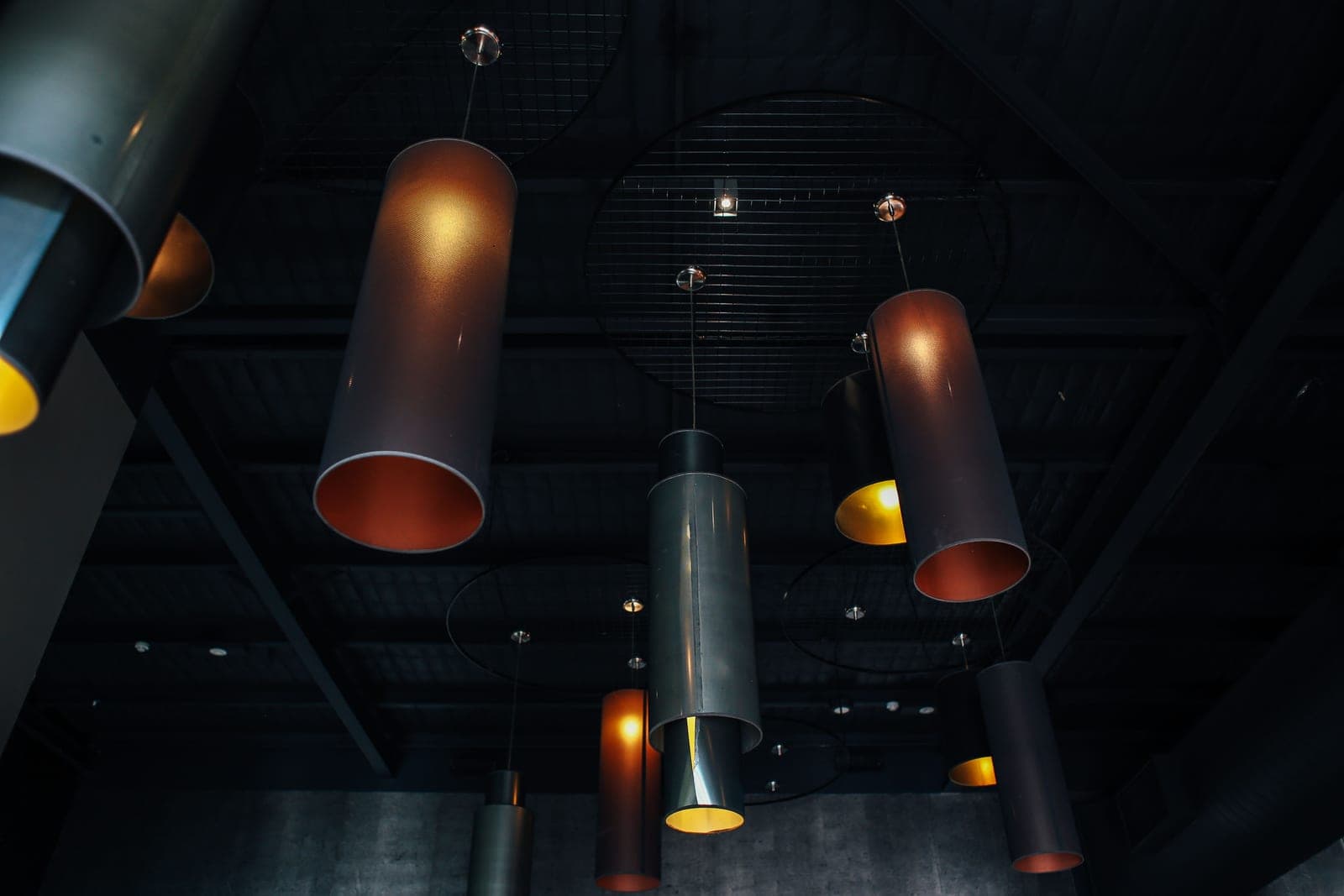 Pendant lamps hanging low over a dark interior with warm pools of light