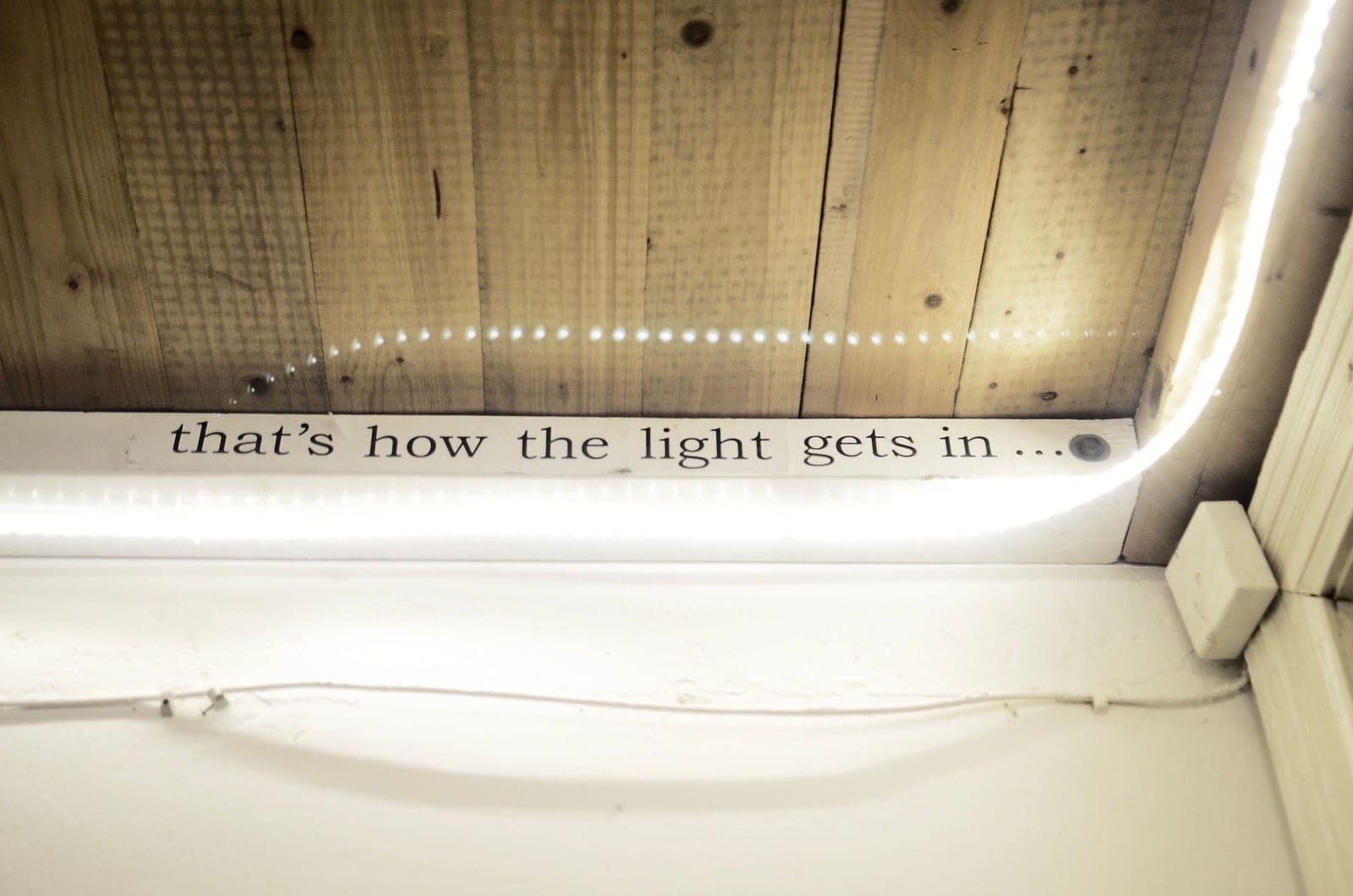 A linear LED fixture mounted above a dark room