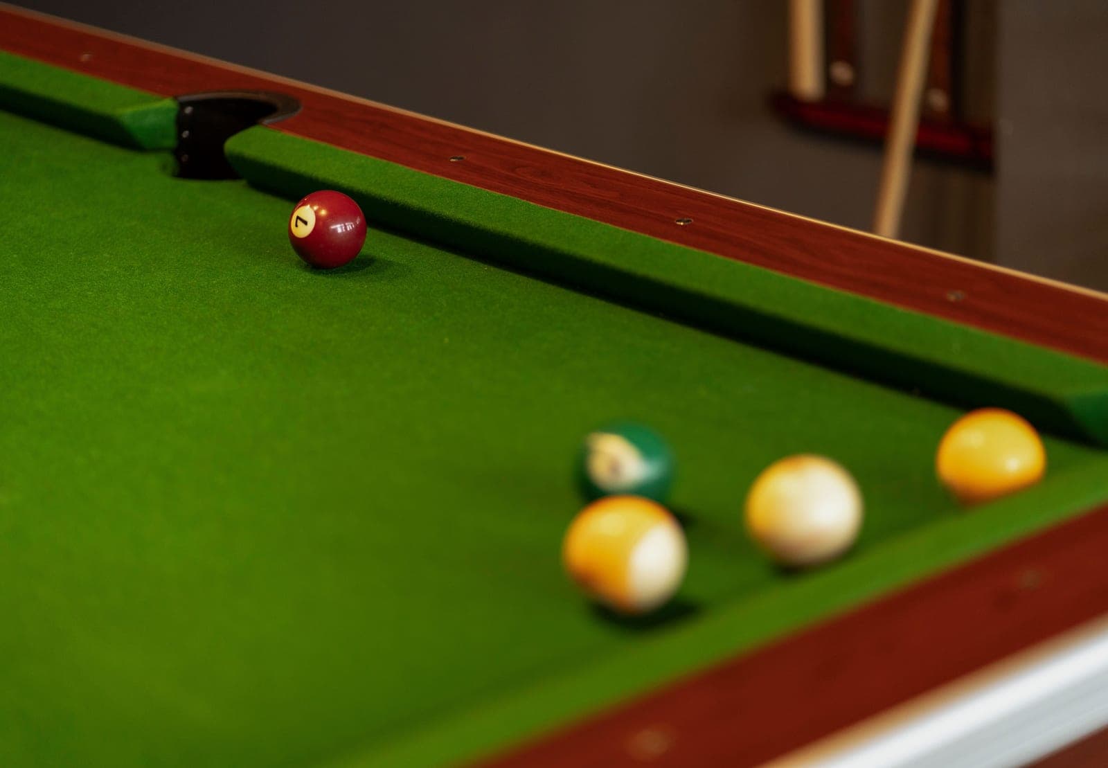 Green cloth and a wooden rail on a home pool table