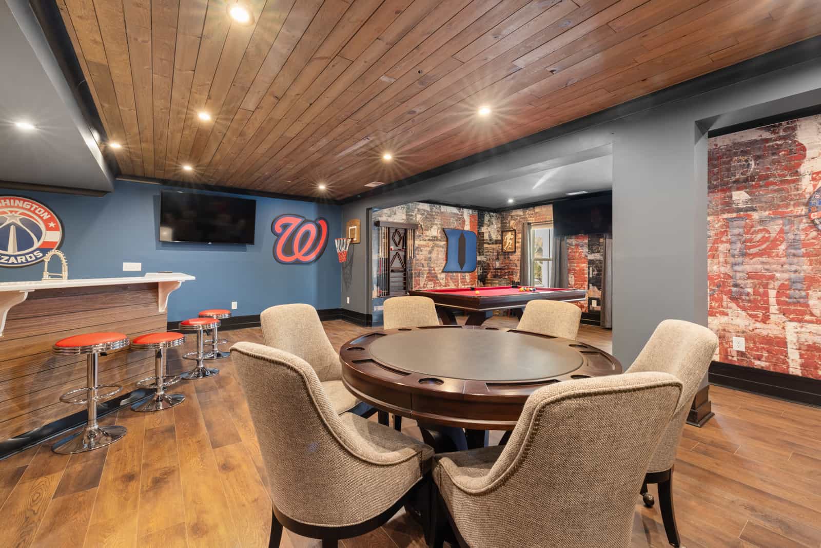 A compact home pool table set up against a basement wall