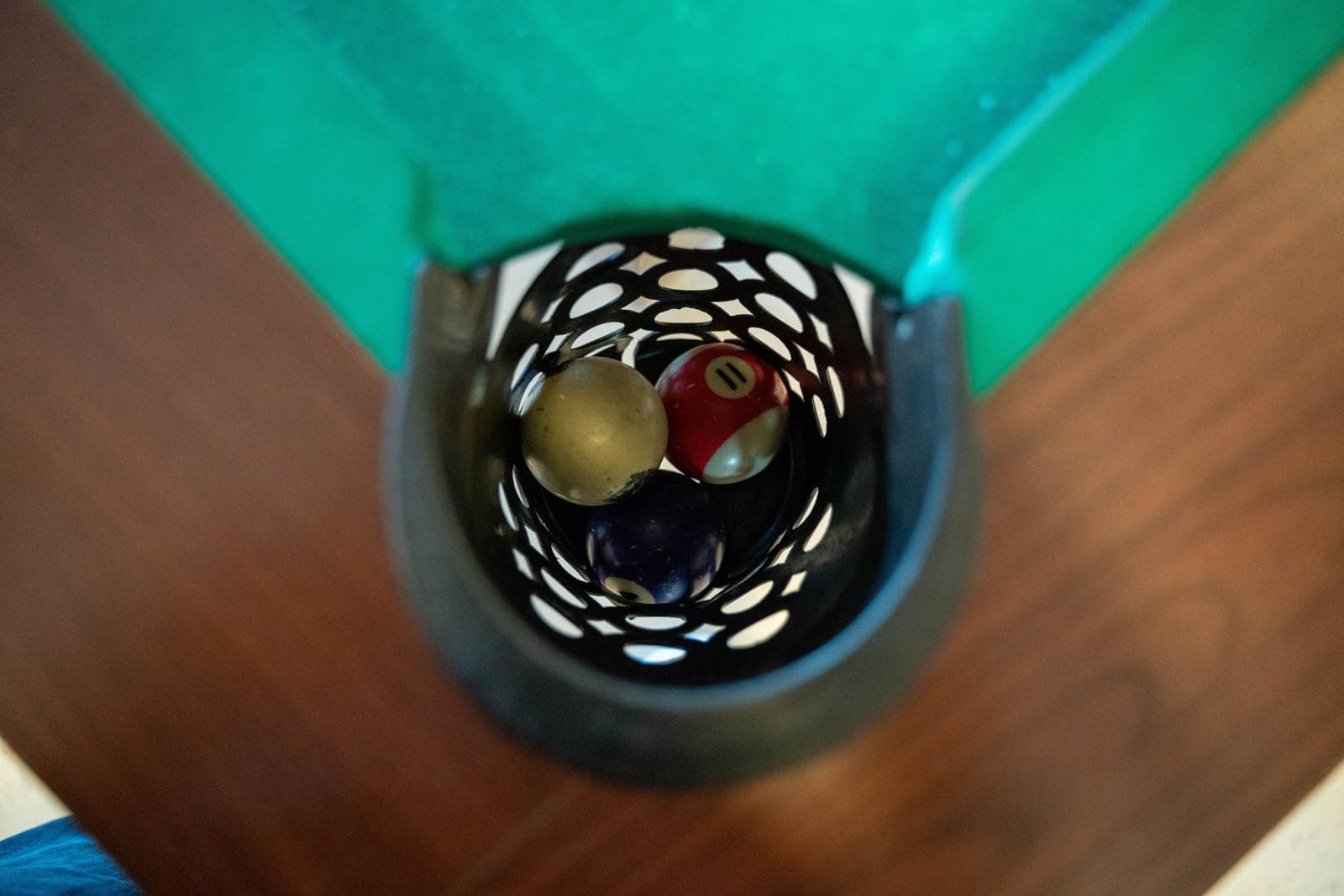 The rail and pocket detail of a pool table showing cloth and cushion wear