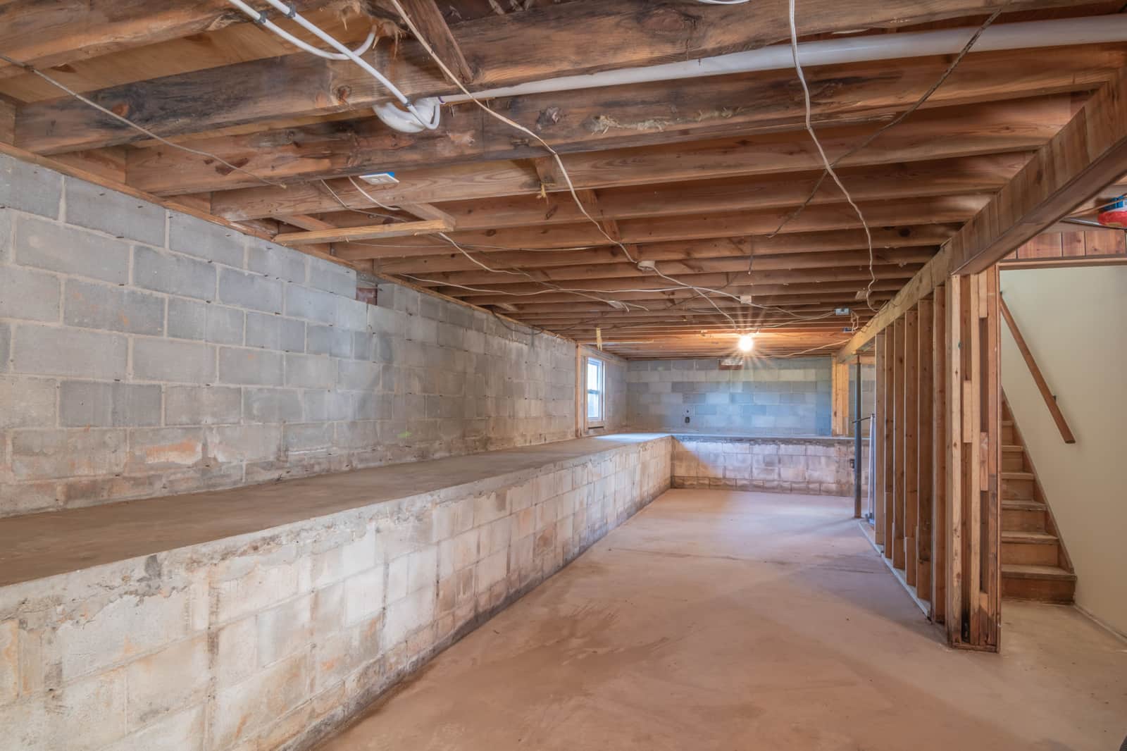 A small unfinished basement space with a support post near one corner