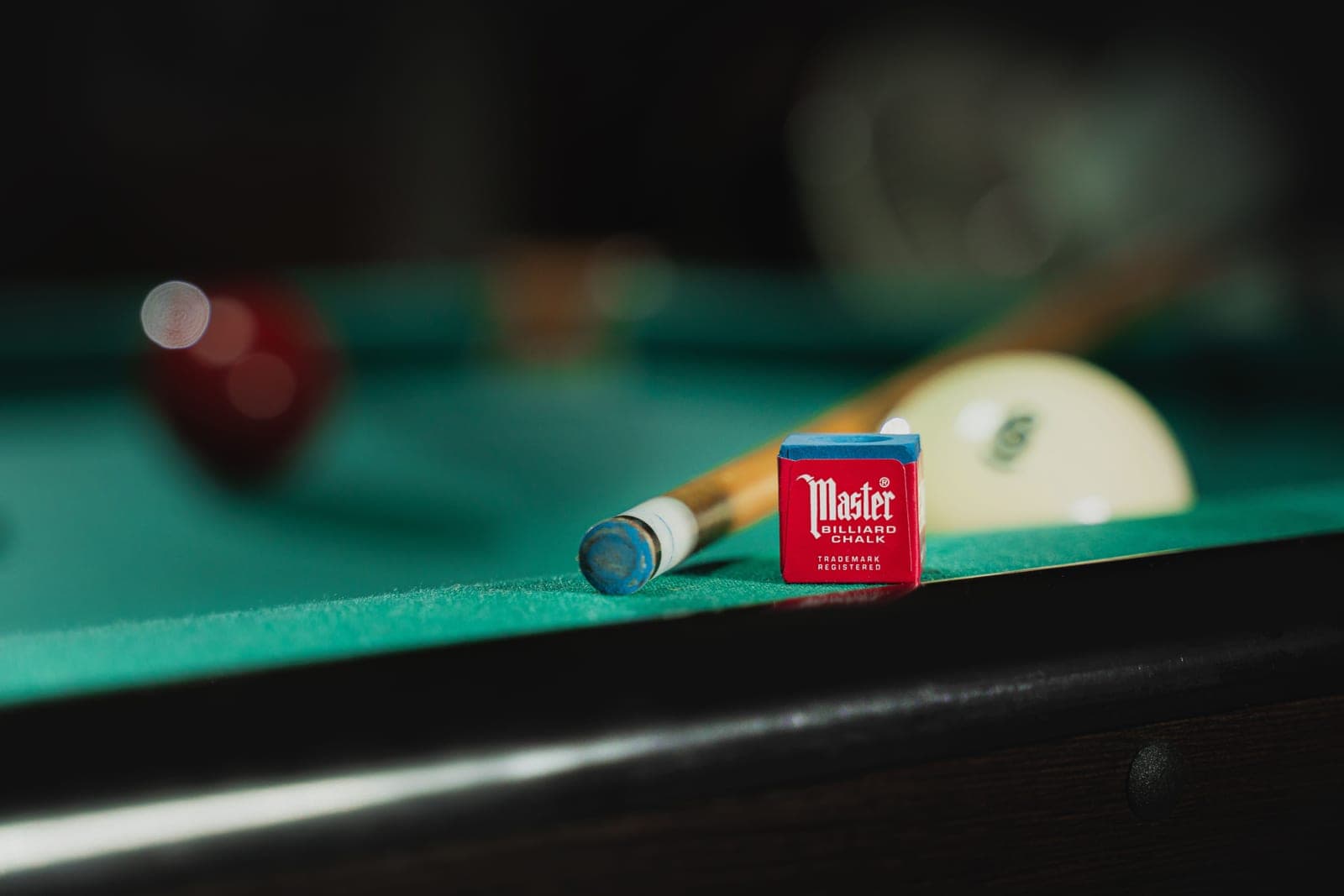 Billiard chalk and small table accessories arranged on a dark surface